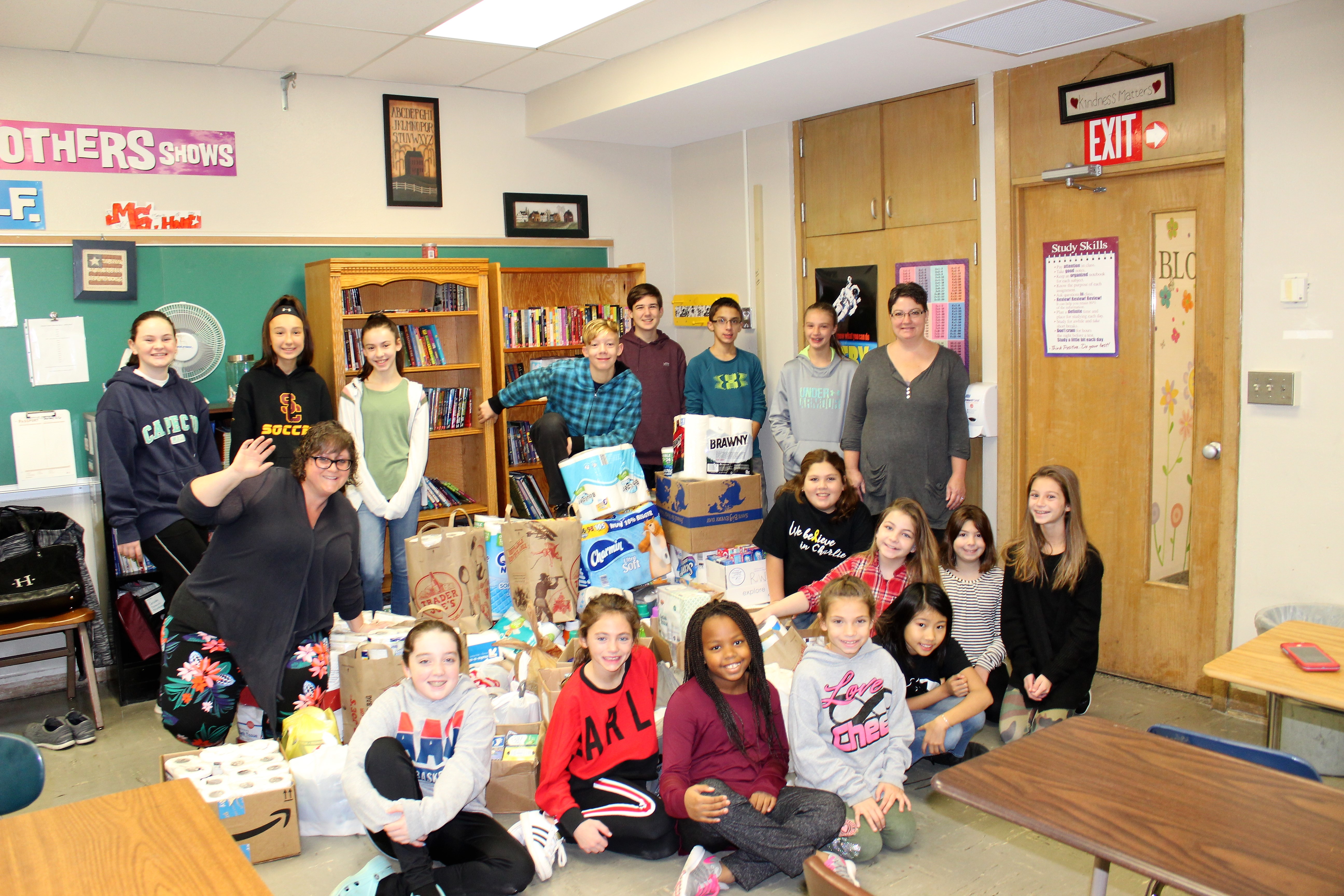 group of middle school students with supplies they collected