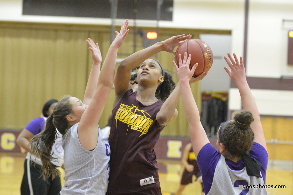 girl takes a basketball shot amongst defenders