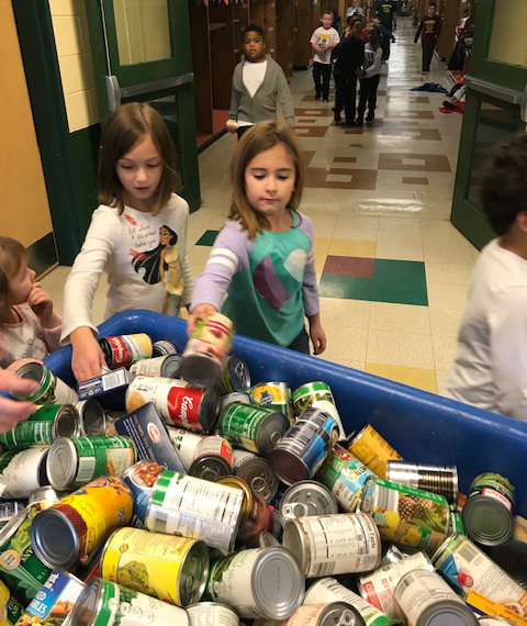 kids load canned good into a large bin