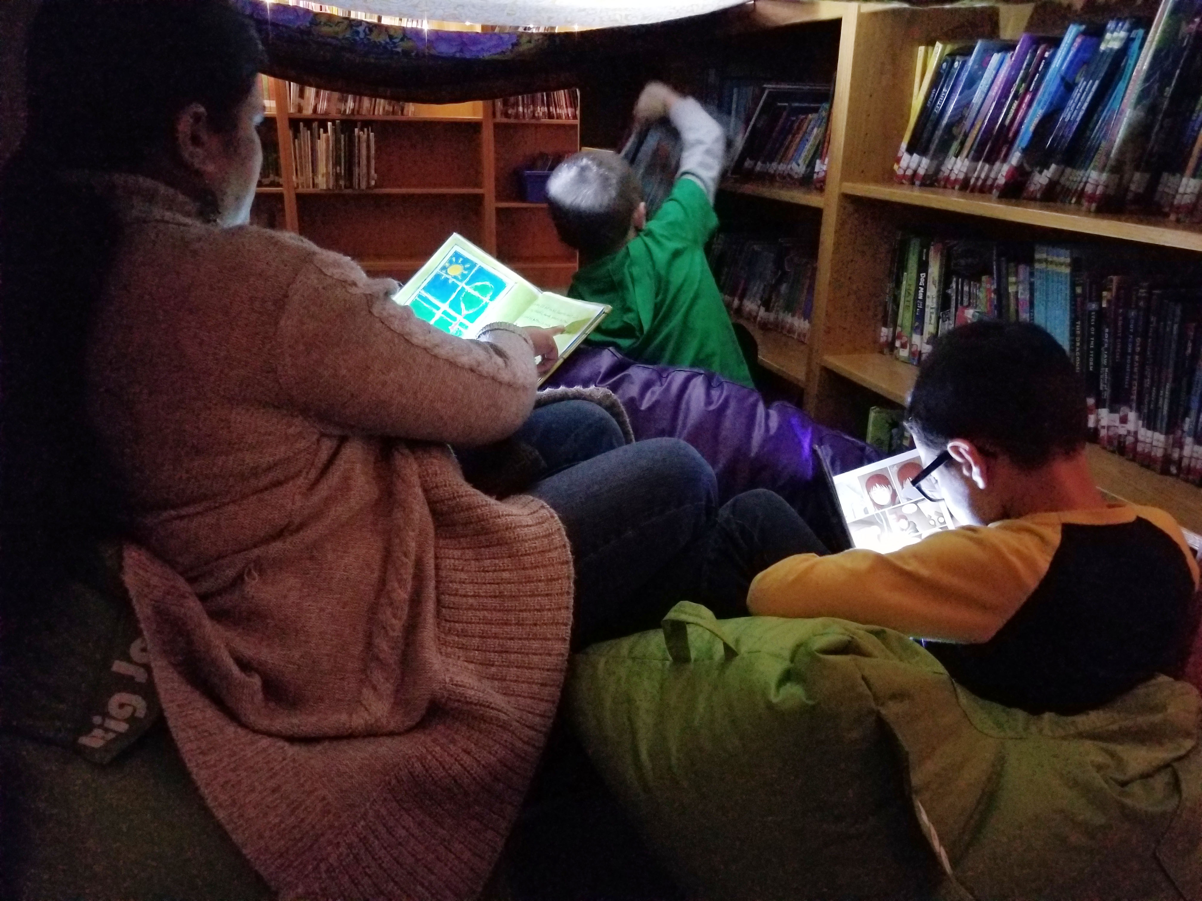 parent and child read by flashlight