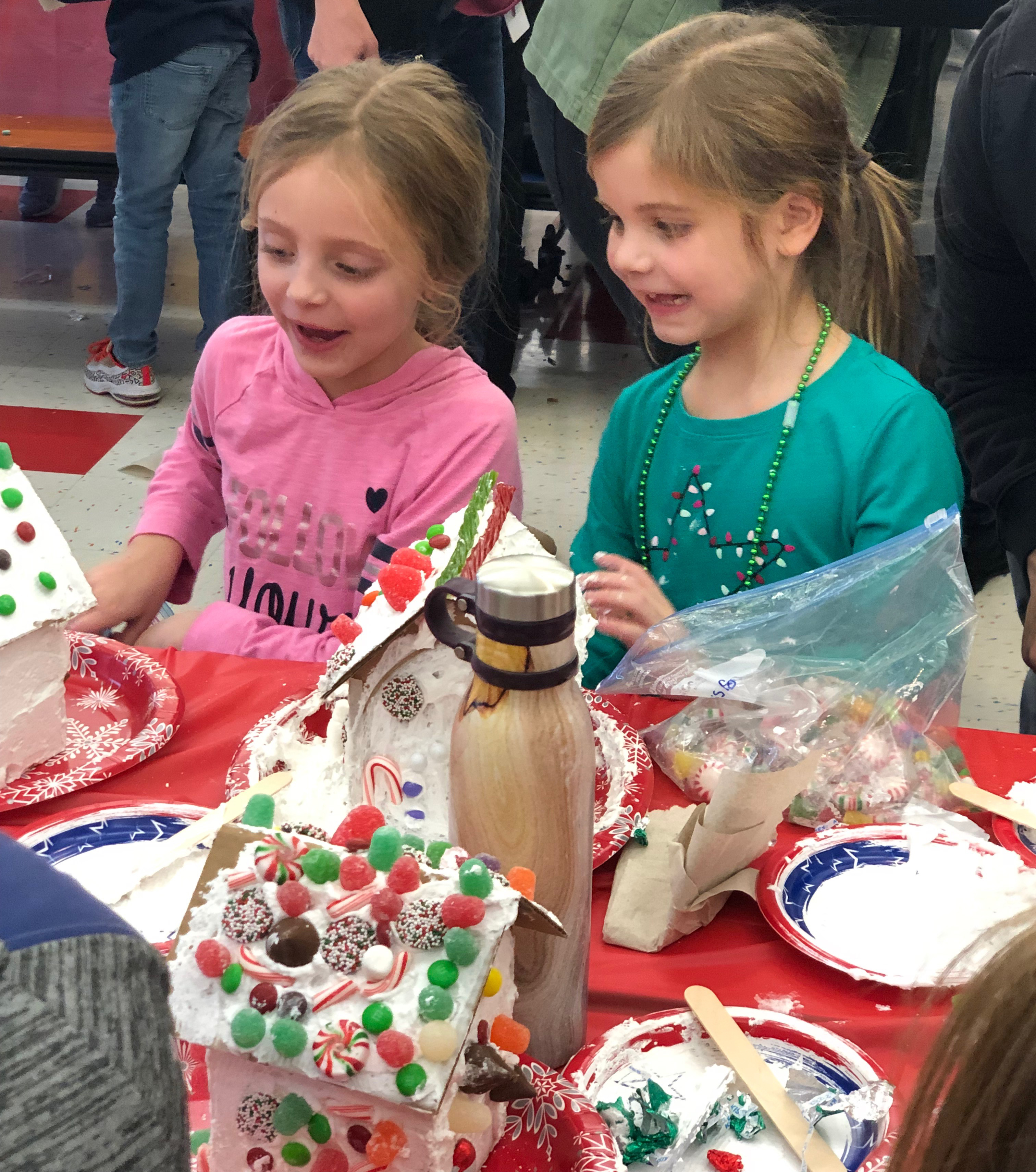 two girls put together a candy house together