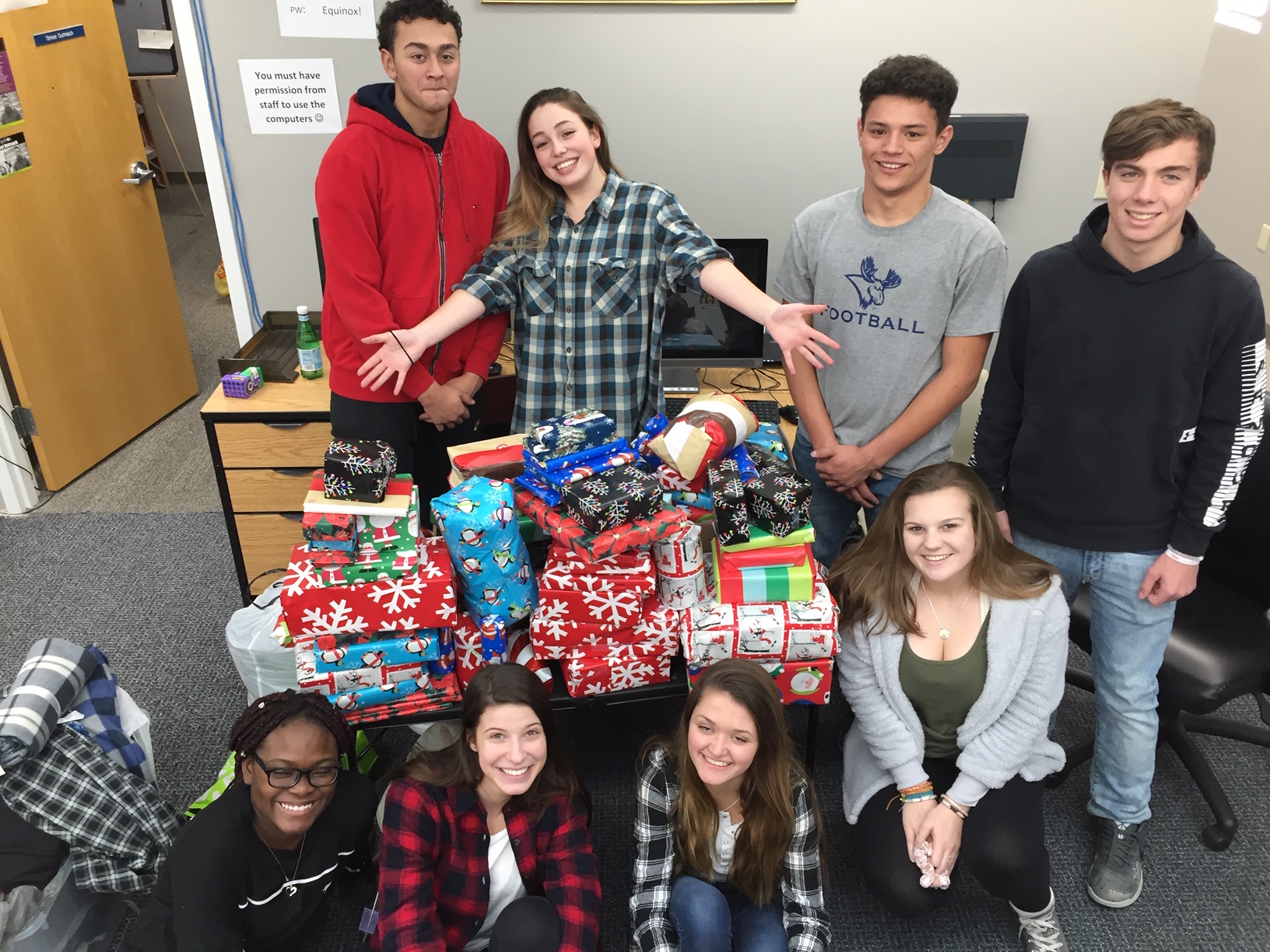 high school students stand in front of van full of goods their collect for charity