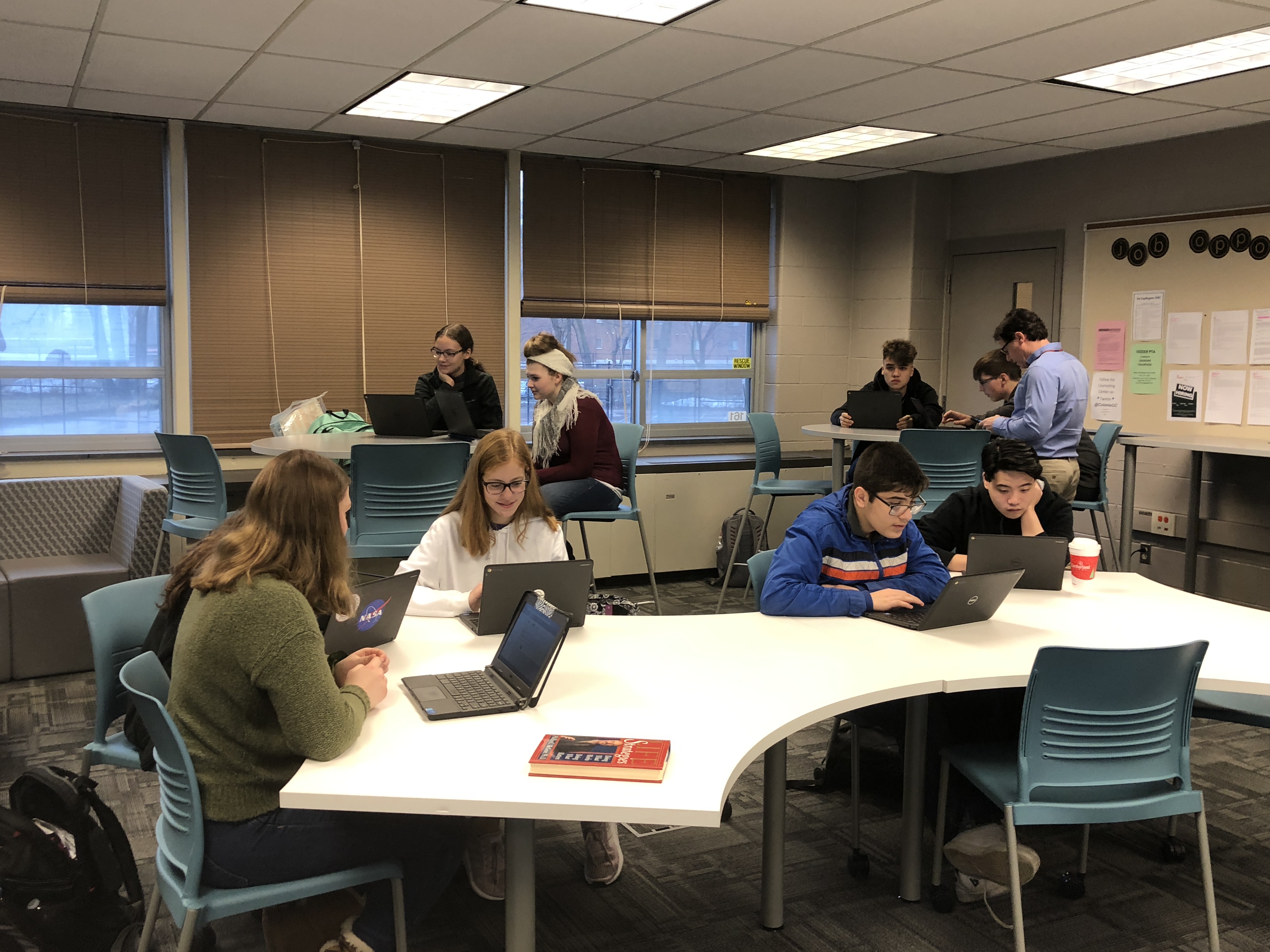 high school students work on laptops in the counseling center