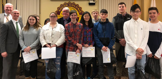 group of high school students stand with her award certificates