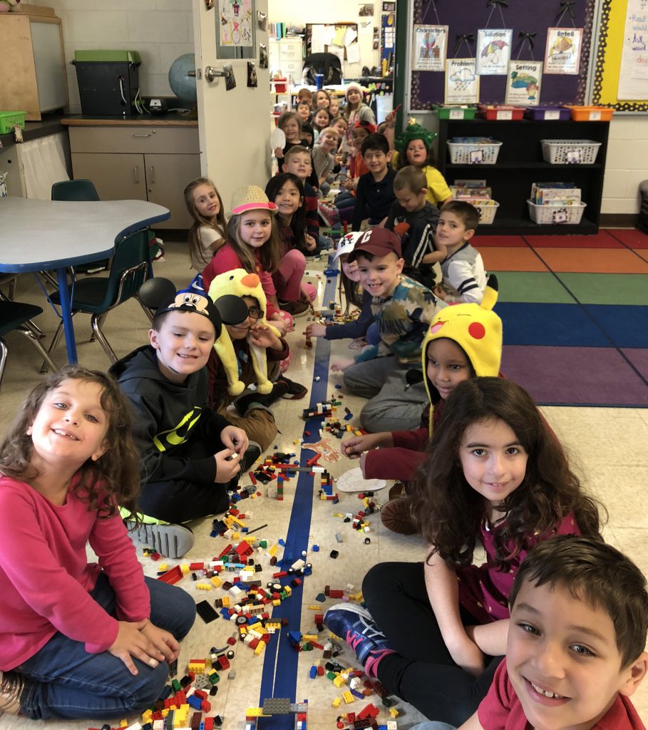 elementary students work together on a project on the floor