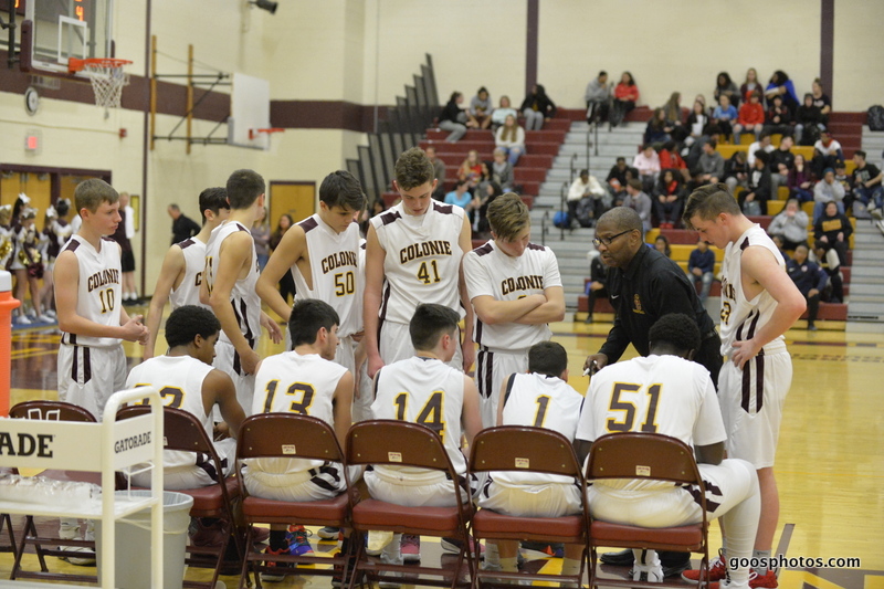 basketball team sits on the bench listening to coach's instructions