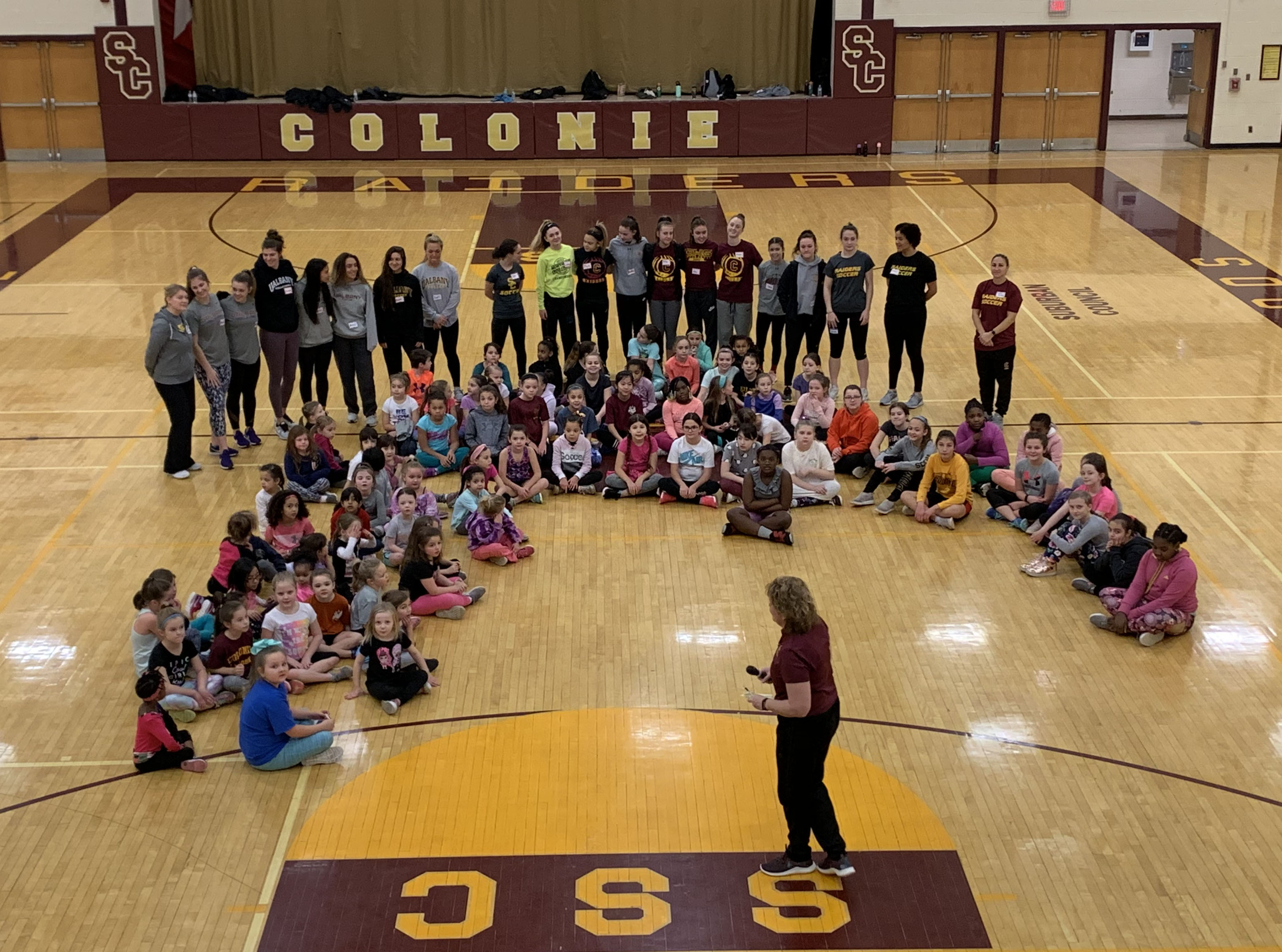 large group of children sitting on gym floor