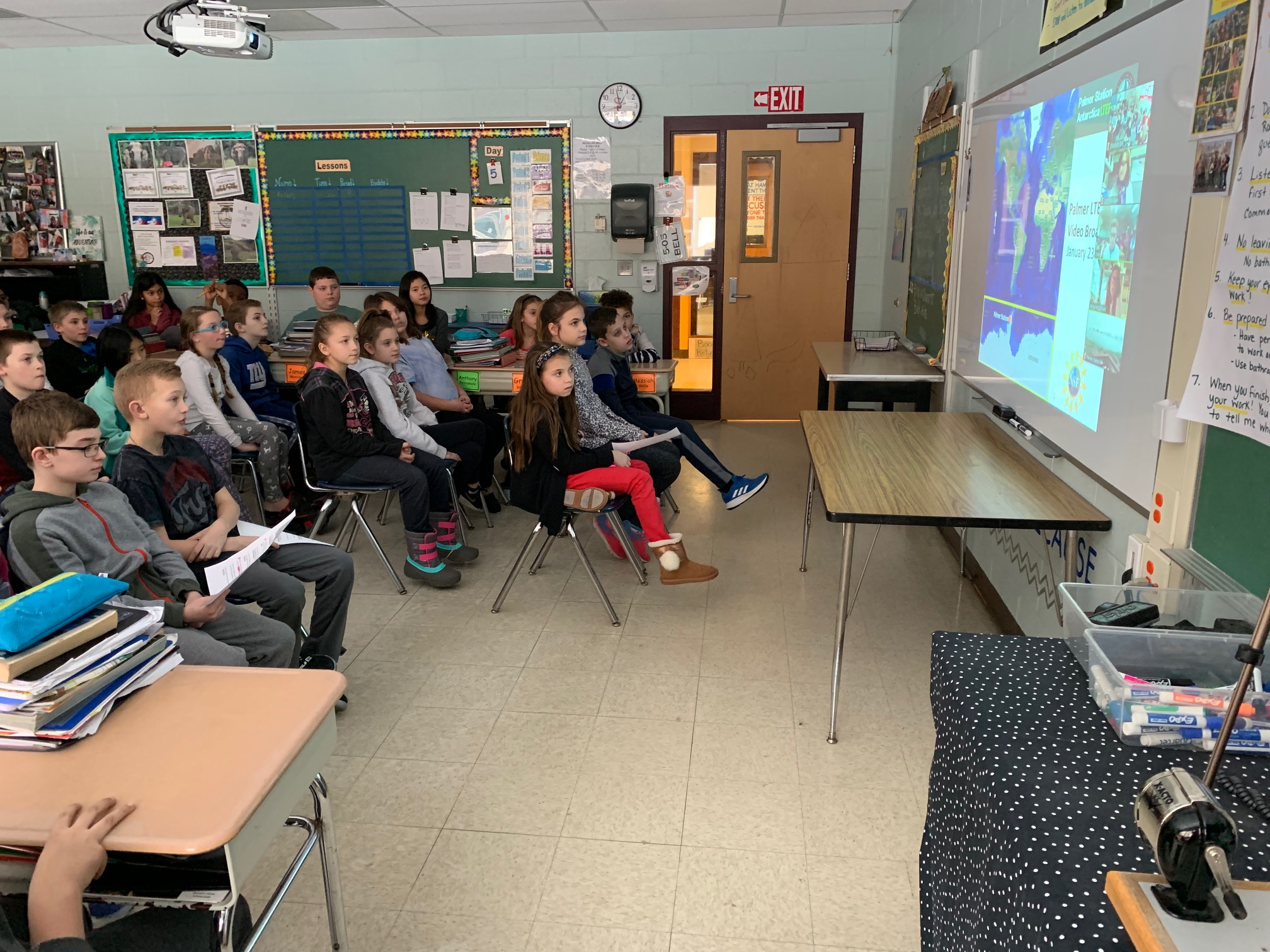 class watches and chats with scientists on a video board