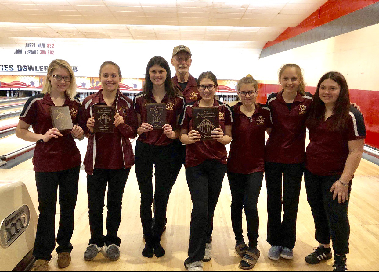 group photo of girls bowling team holding up winning plaques