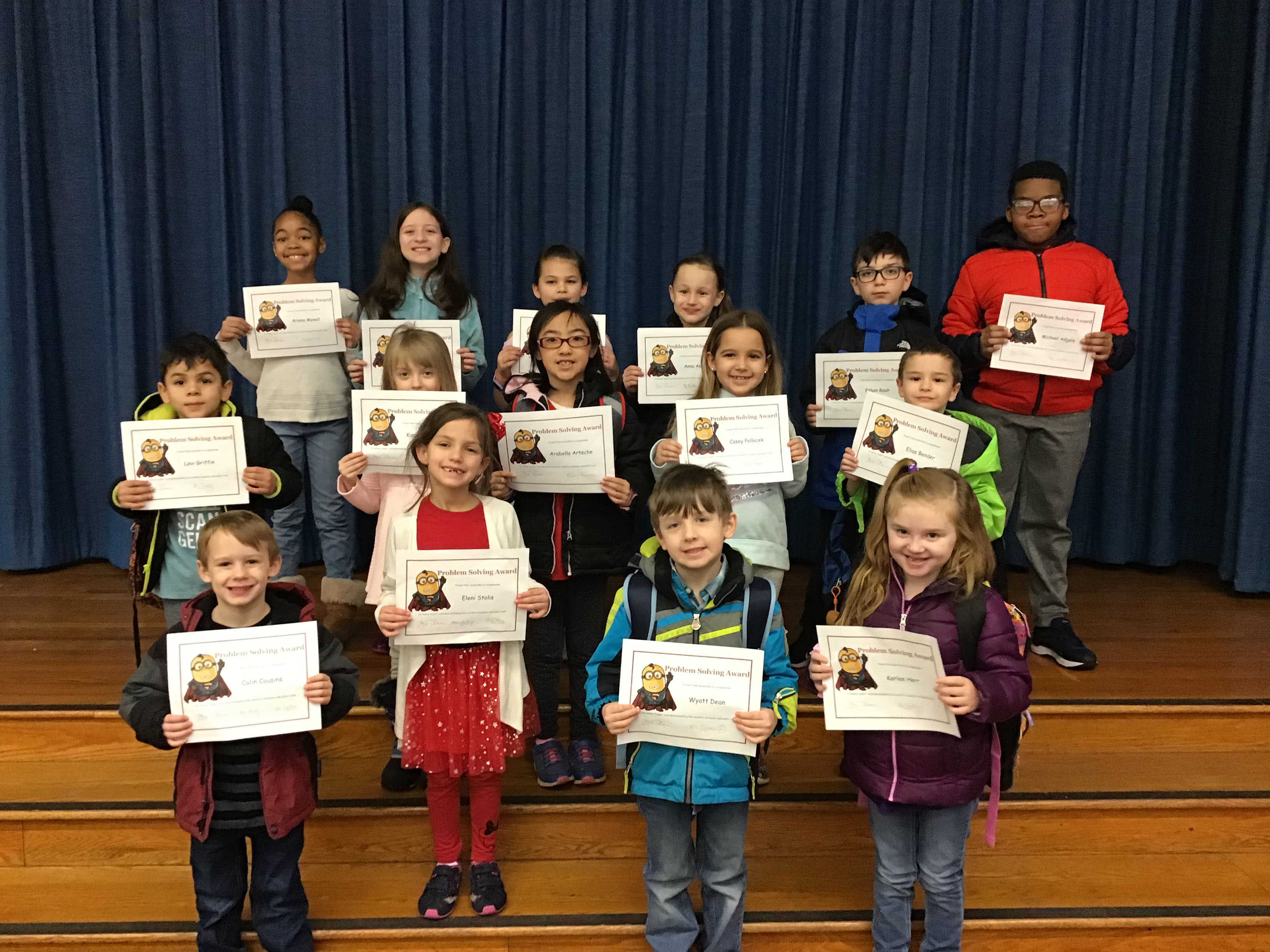 group of children stand with their award certificates