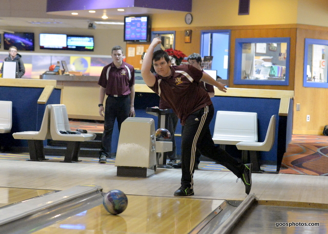 male bowler rolls a ball down the lane