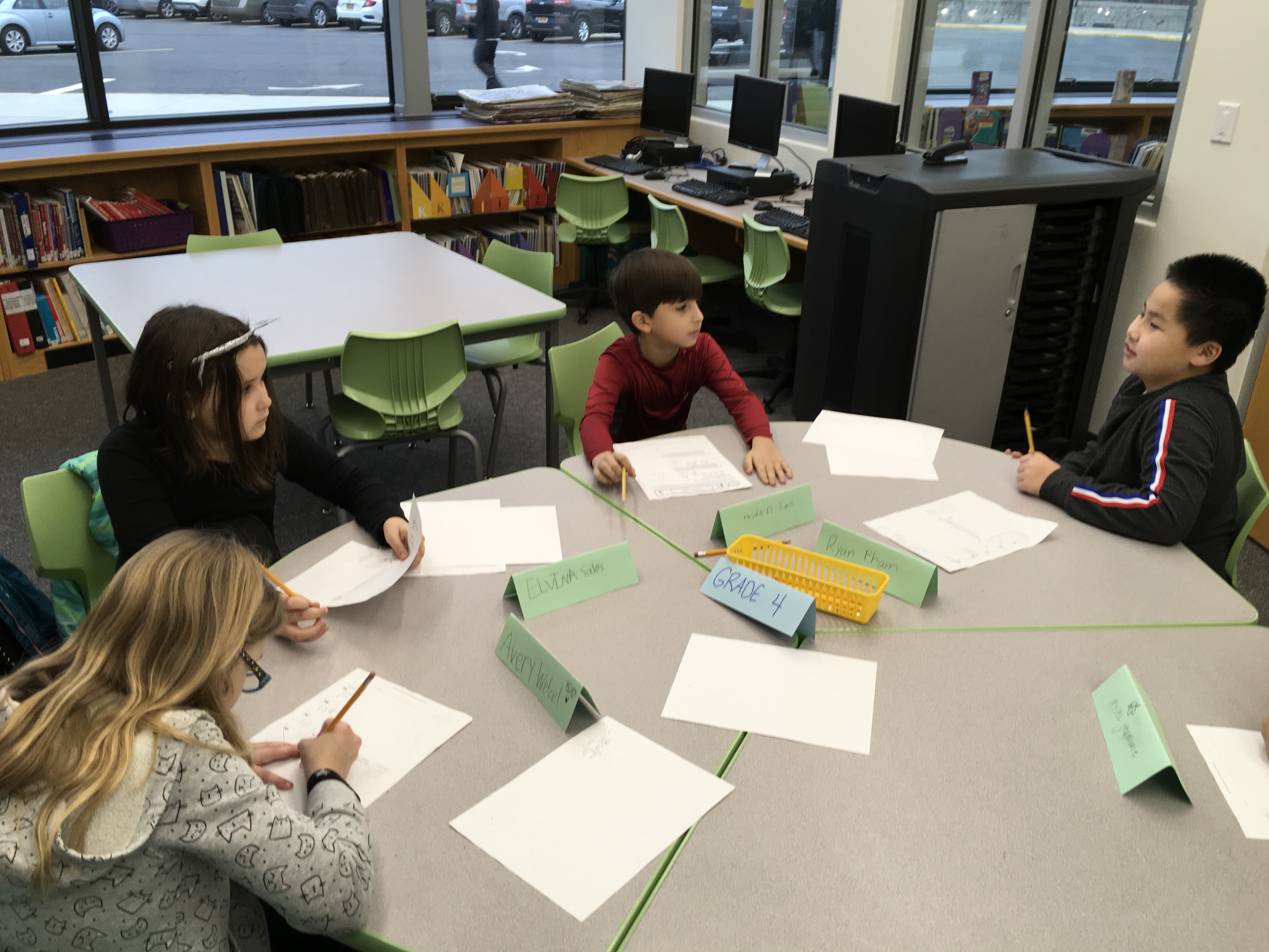 group of students work on math problems at a large table