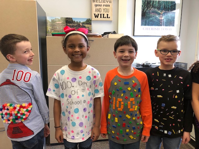 4 students show off their 100 day shirts