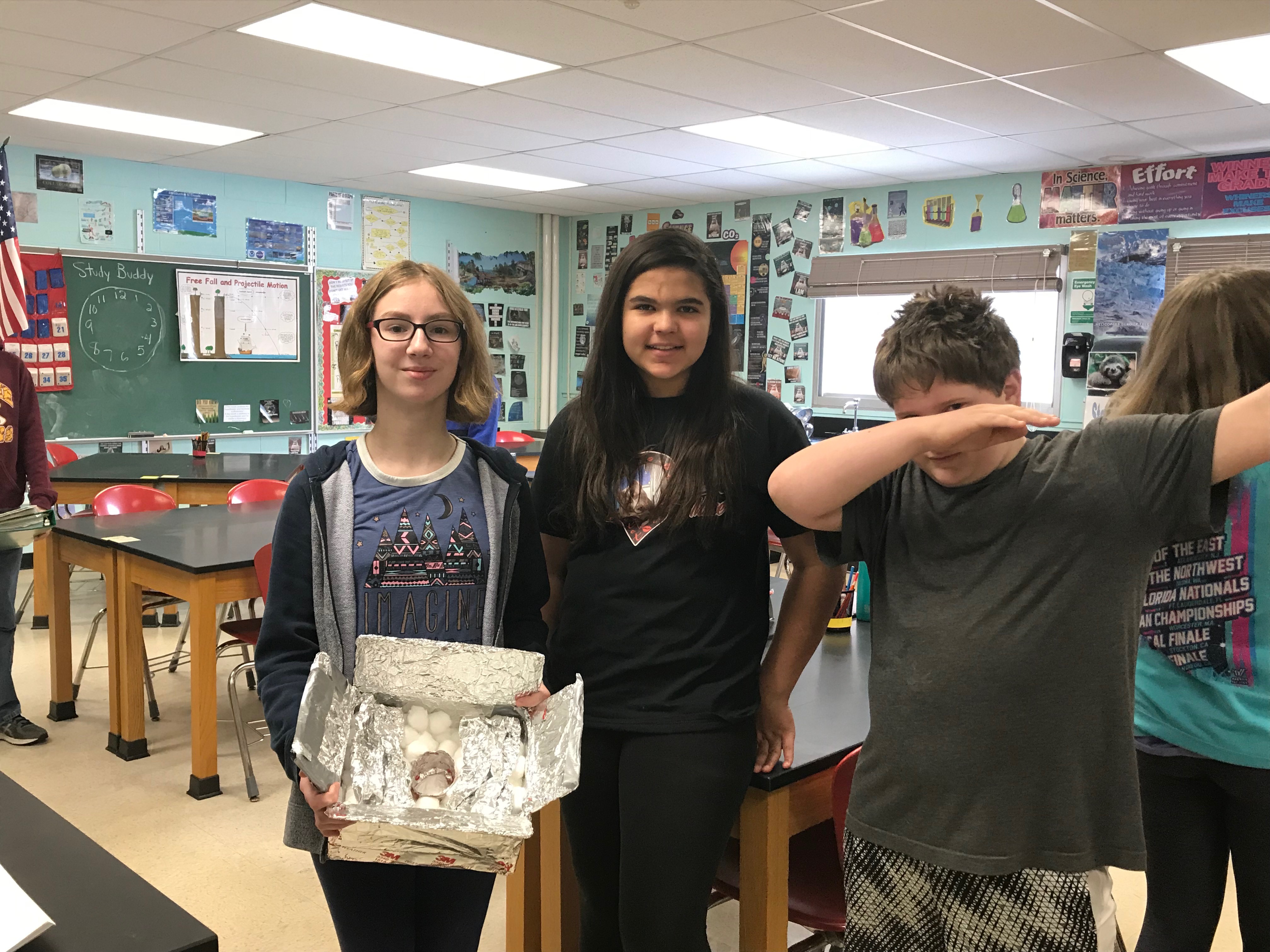 three students show off their soup insulator