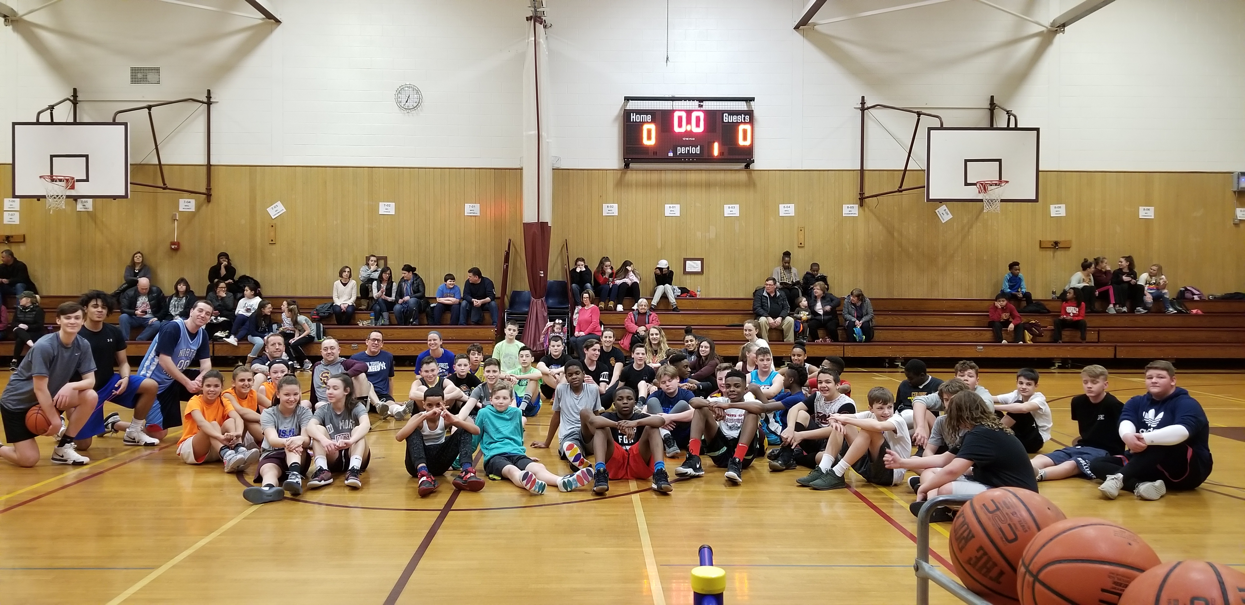 large group of basketball players sprawled out on gym floor