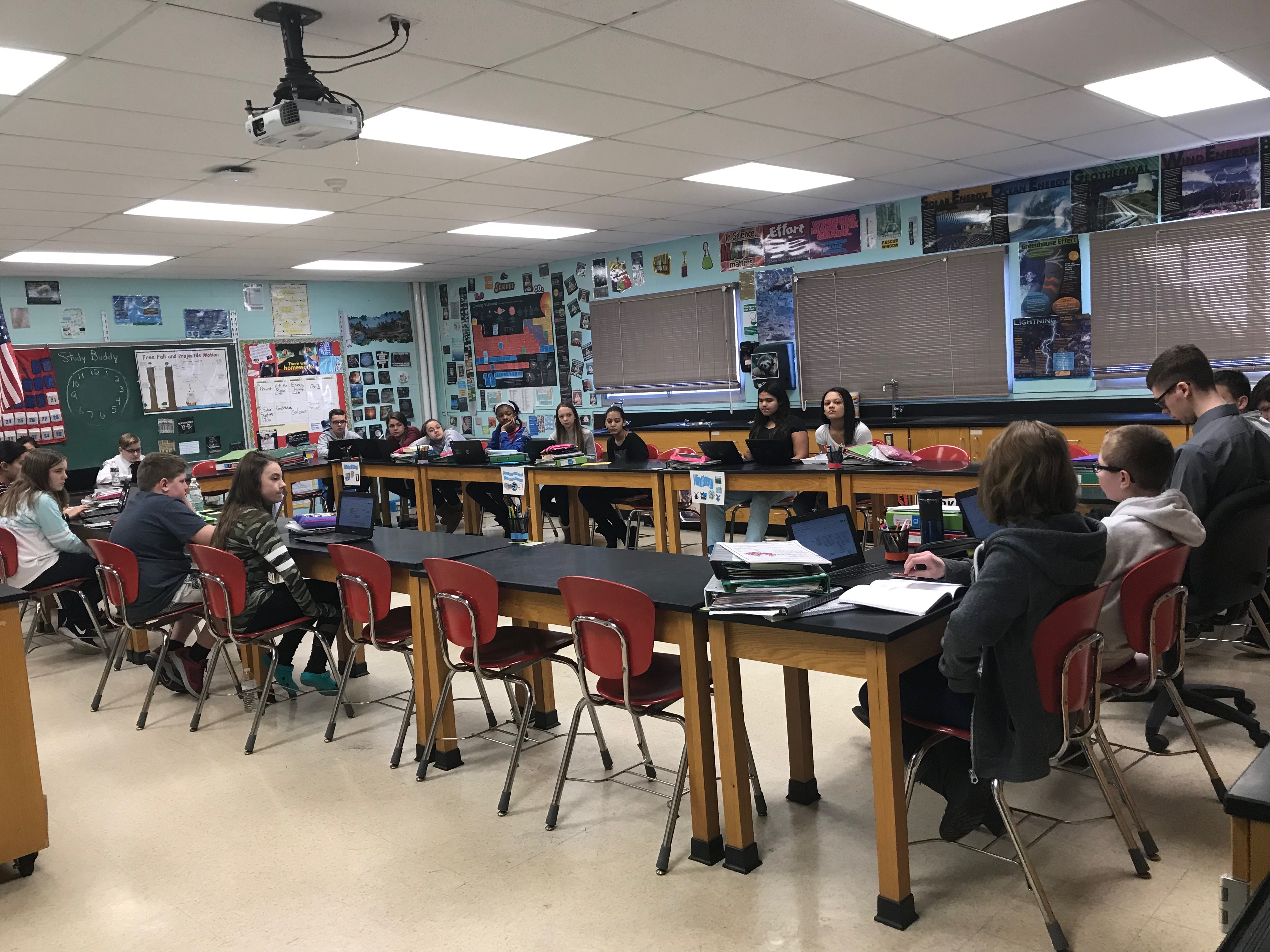 students sit at a large table debating