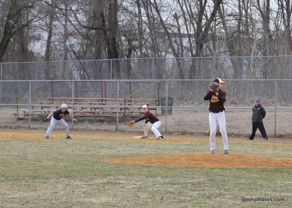 pitcher on the mound looking at runner on first base