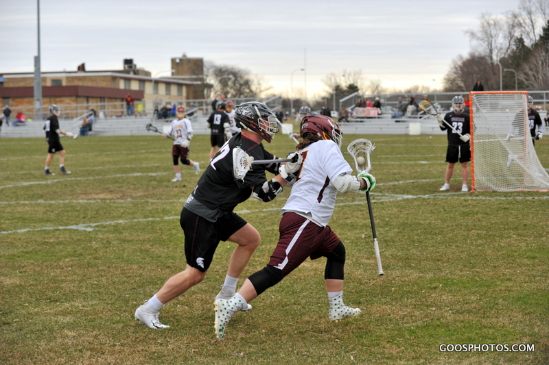 two lacrosse players bump at mid field