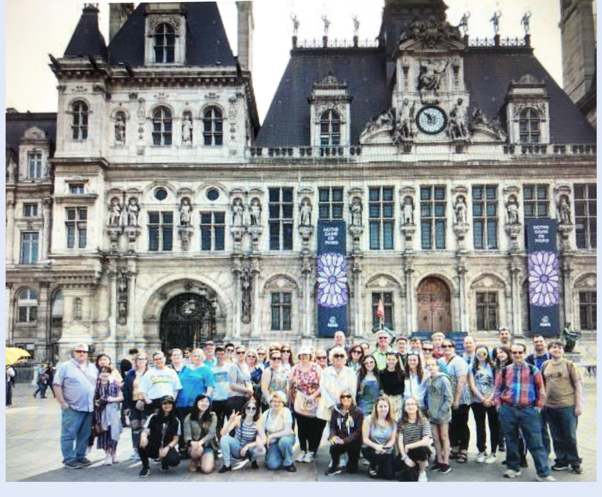 large group of people outside a French building