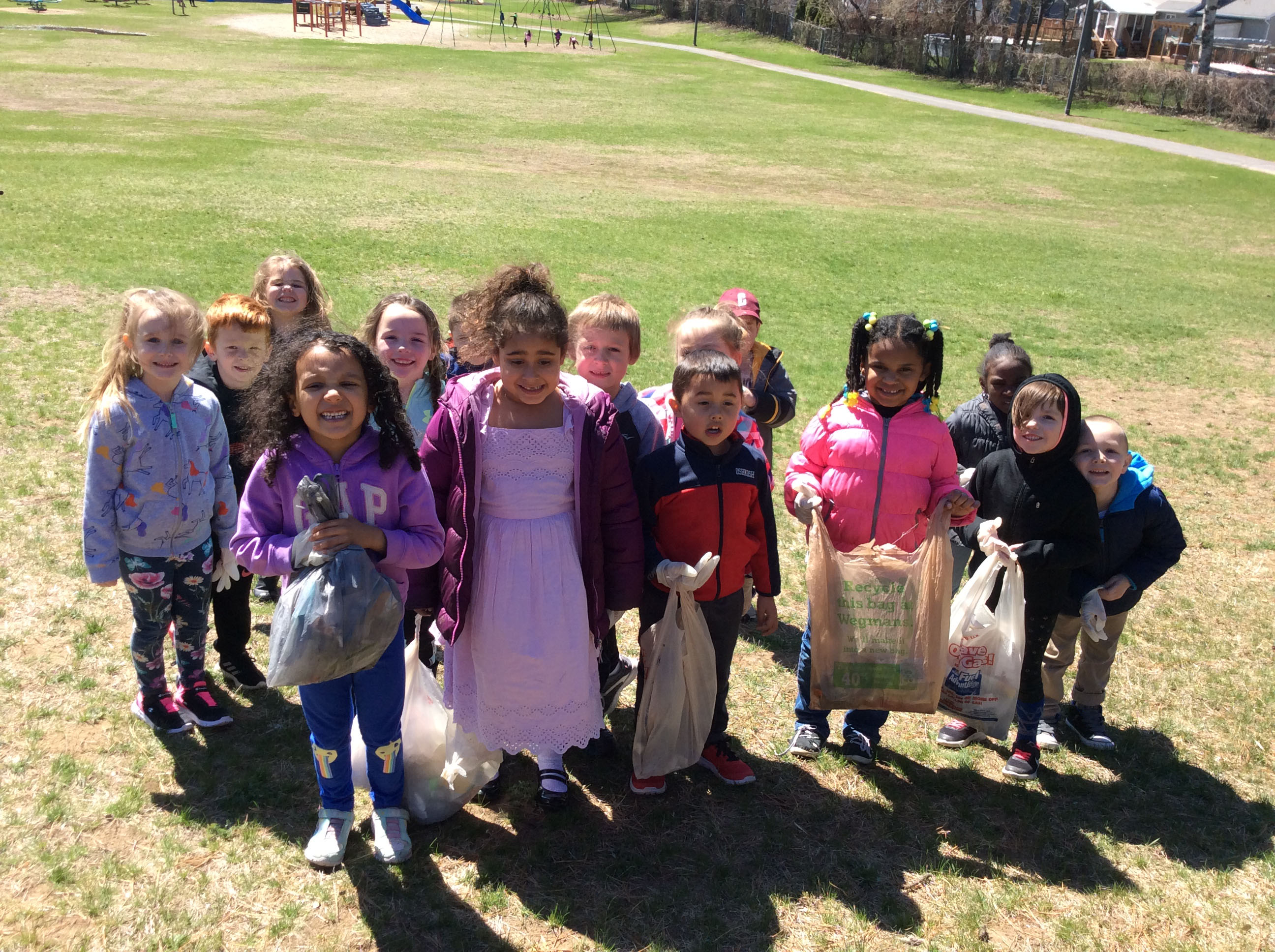 group of Kindergartners pick up trash outside