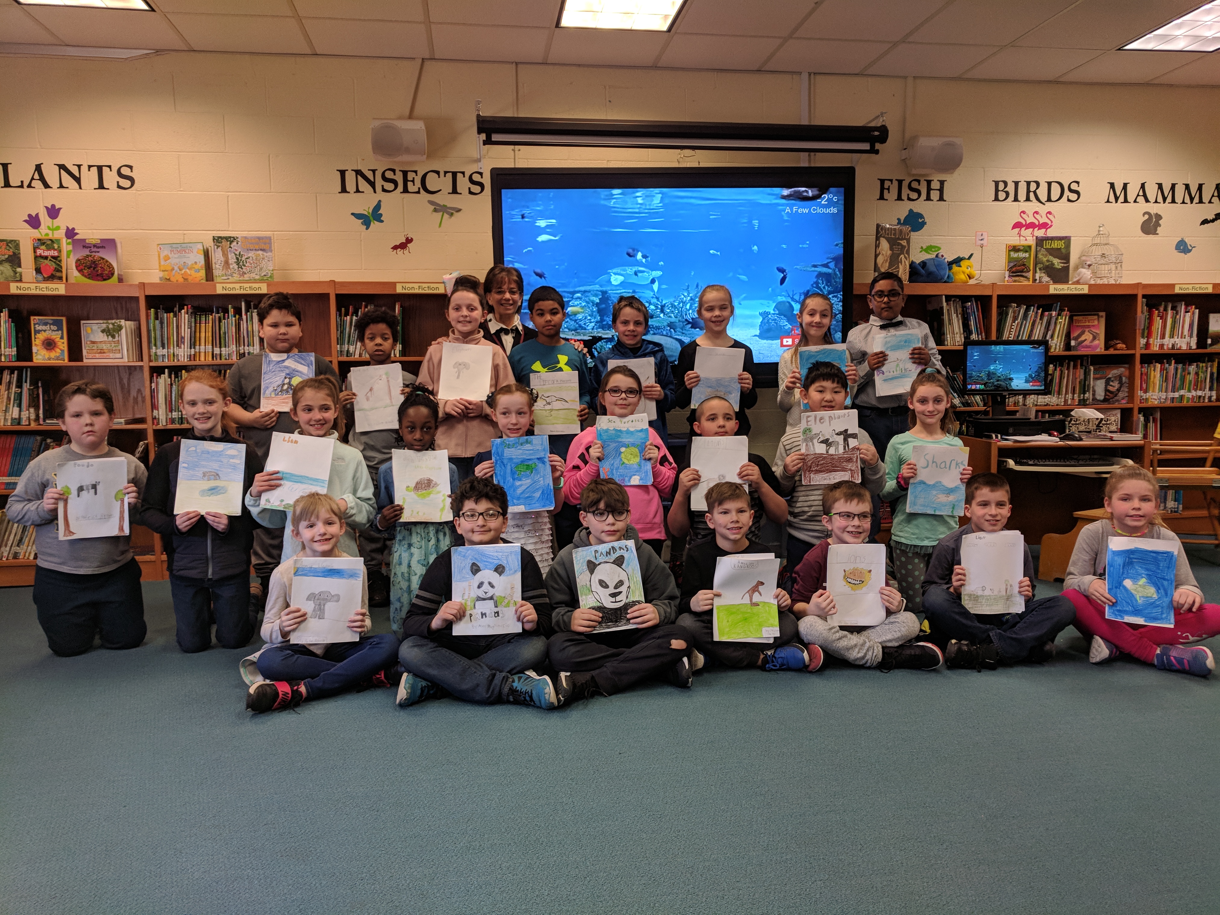 group of students show off their completed writing projects