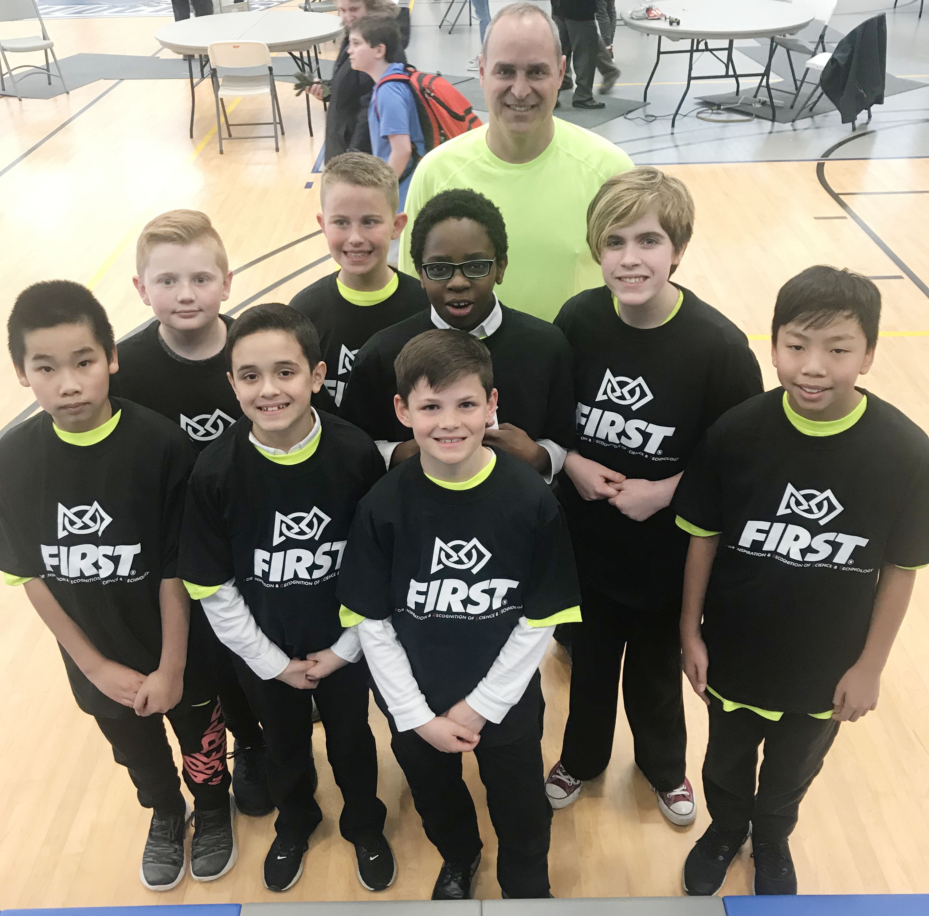 group of students wearing their brown team shirts and their coach