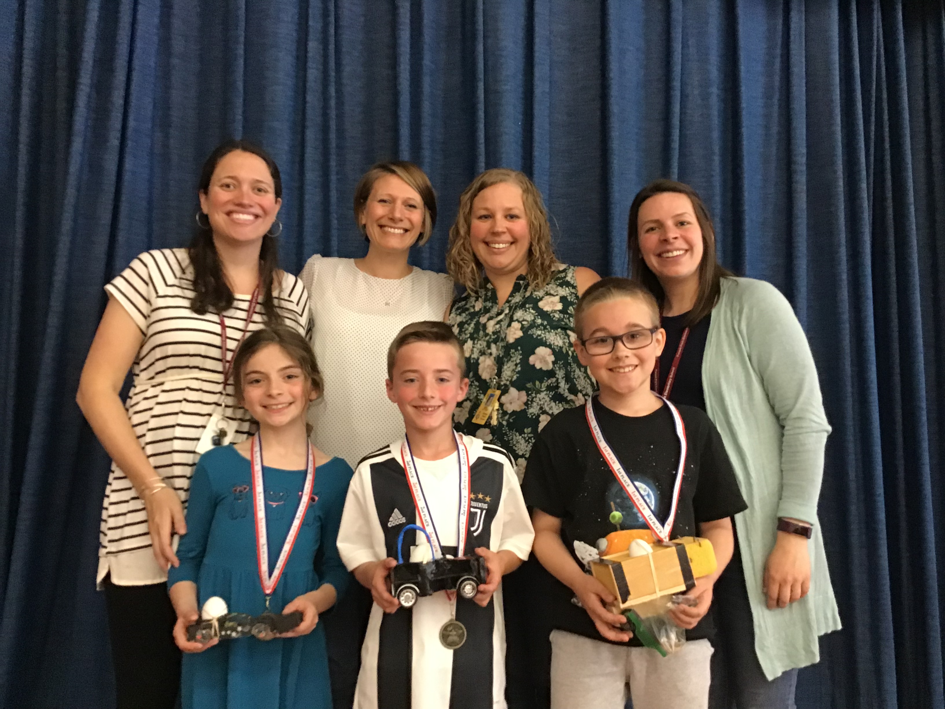 four teachers and three students with their awards