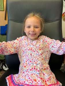 smiling girl sits in a big chair