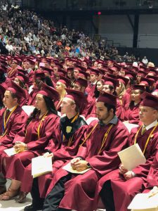 graduates seated in their caps and gowns