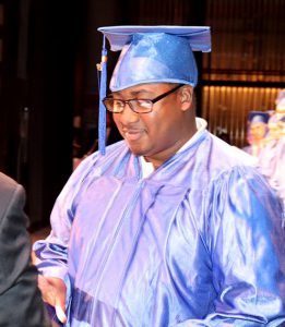 man dressed in blue cap and gown