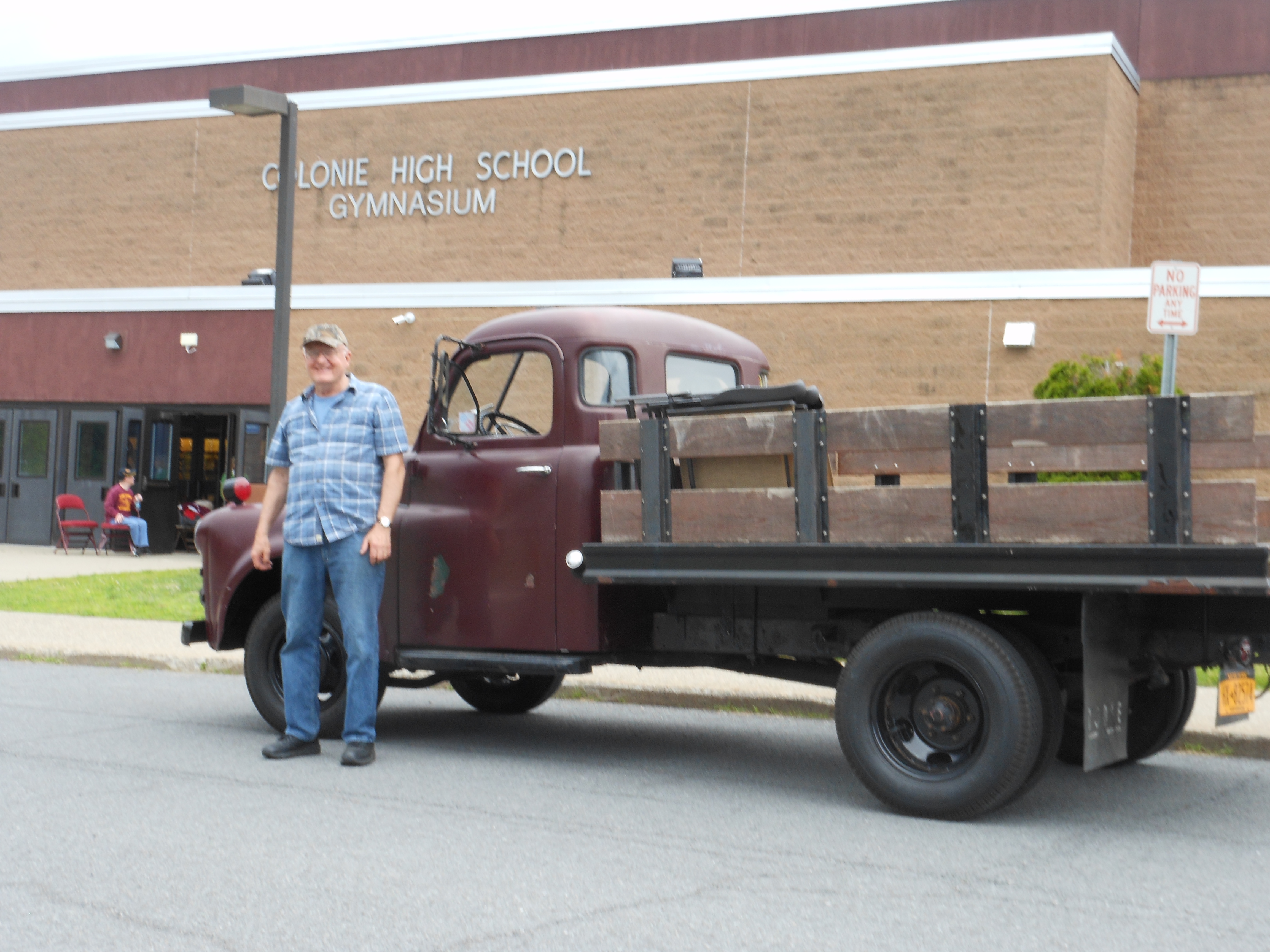 man stands in front of his antique truck