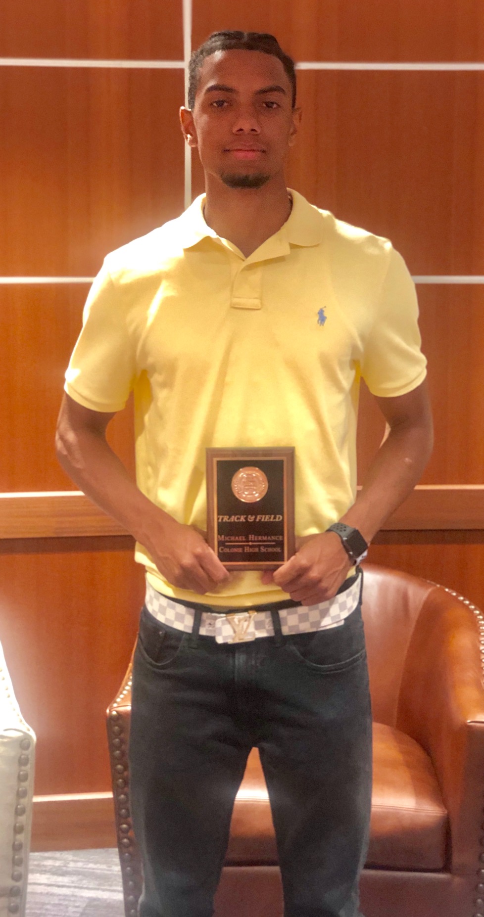 athlete holds his award plaque