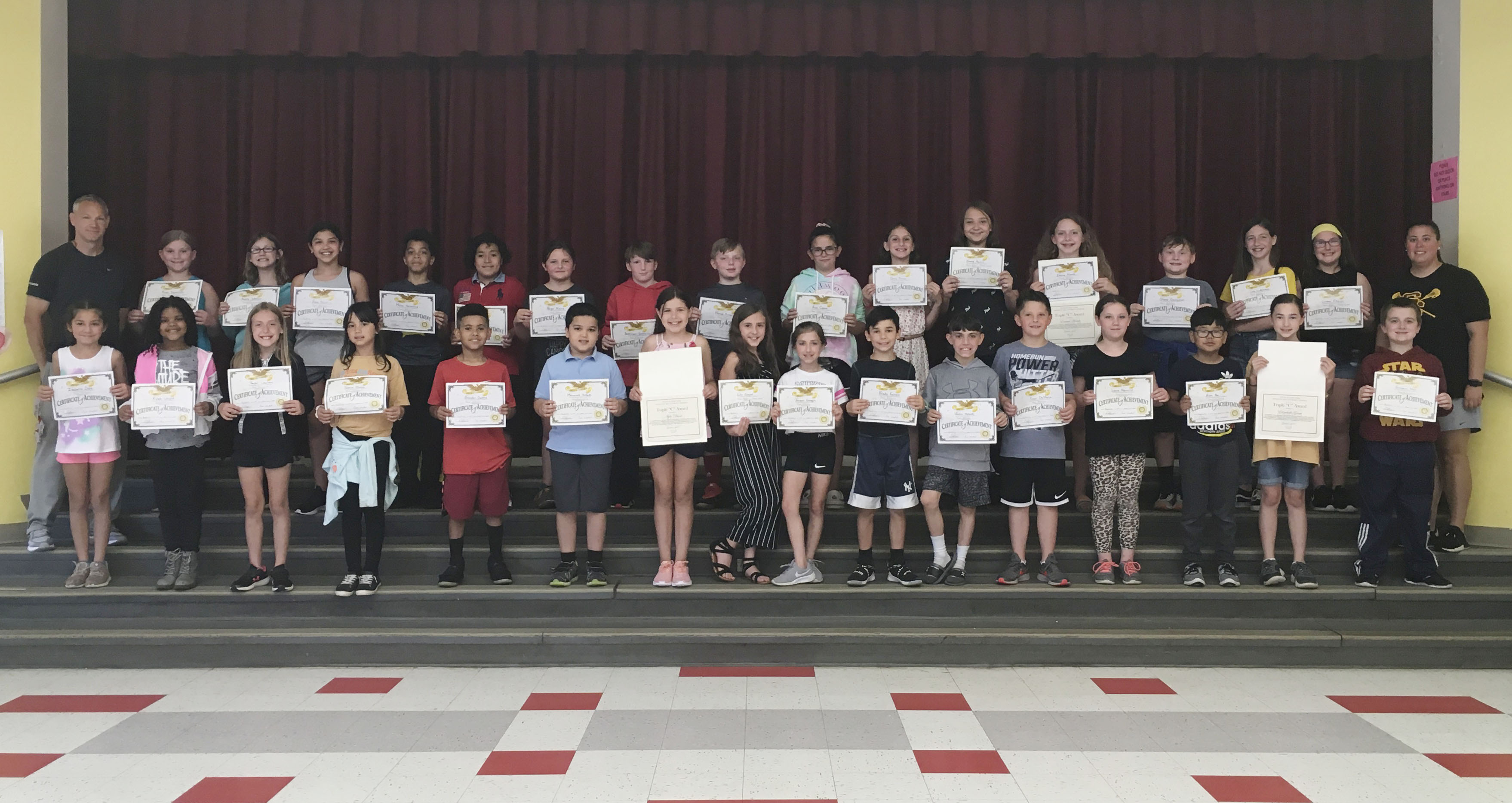 group of elementary student show off their award certificates