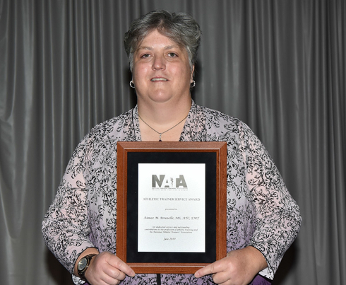 woman holds awards plaque