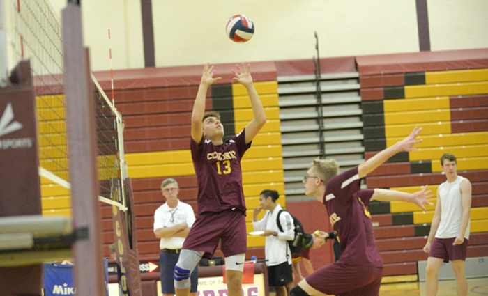 volleyball players set up teammate at the net