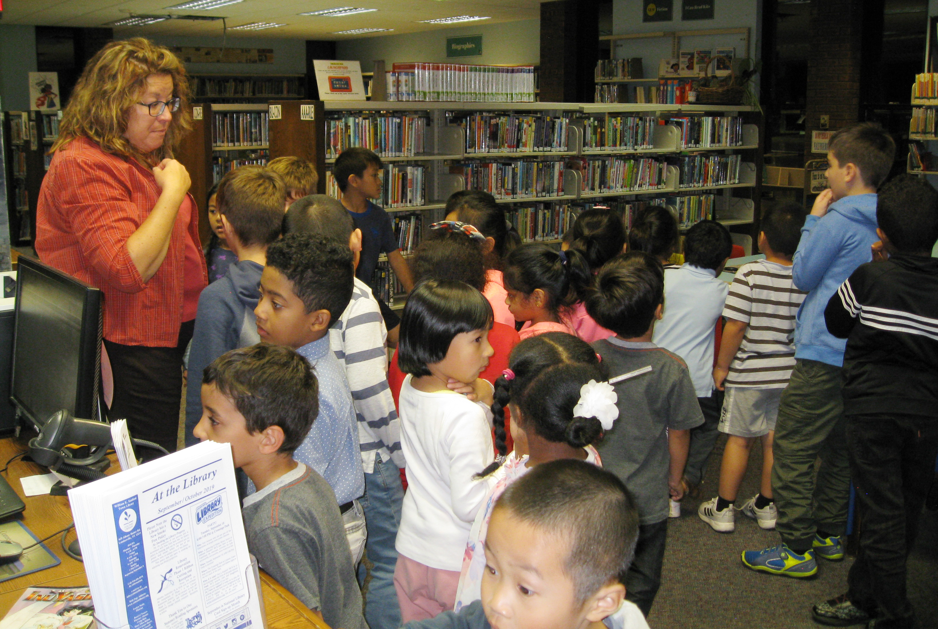 large group of students mingle around the library