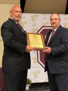 two men hold a plaque together