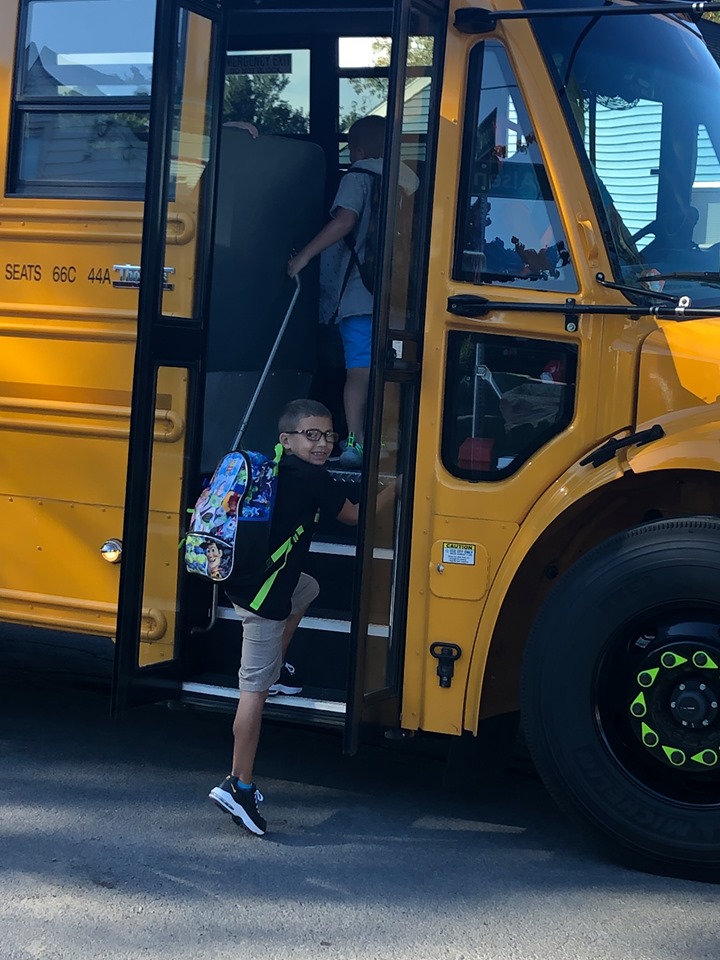 child boards a school bus