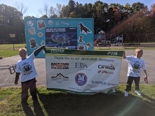 two boys hold a large banner