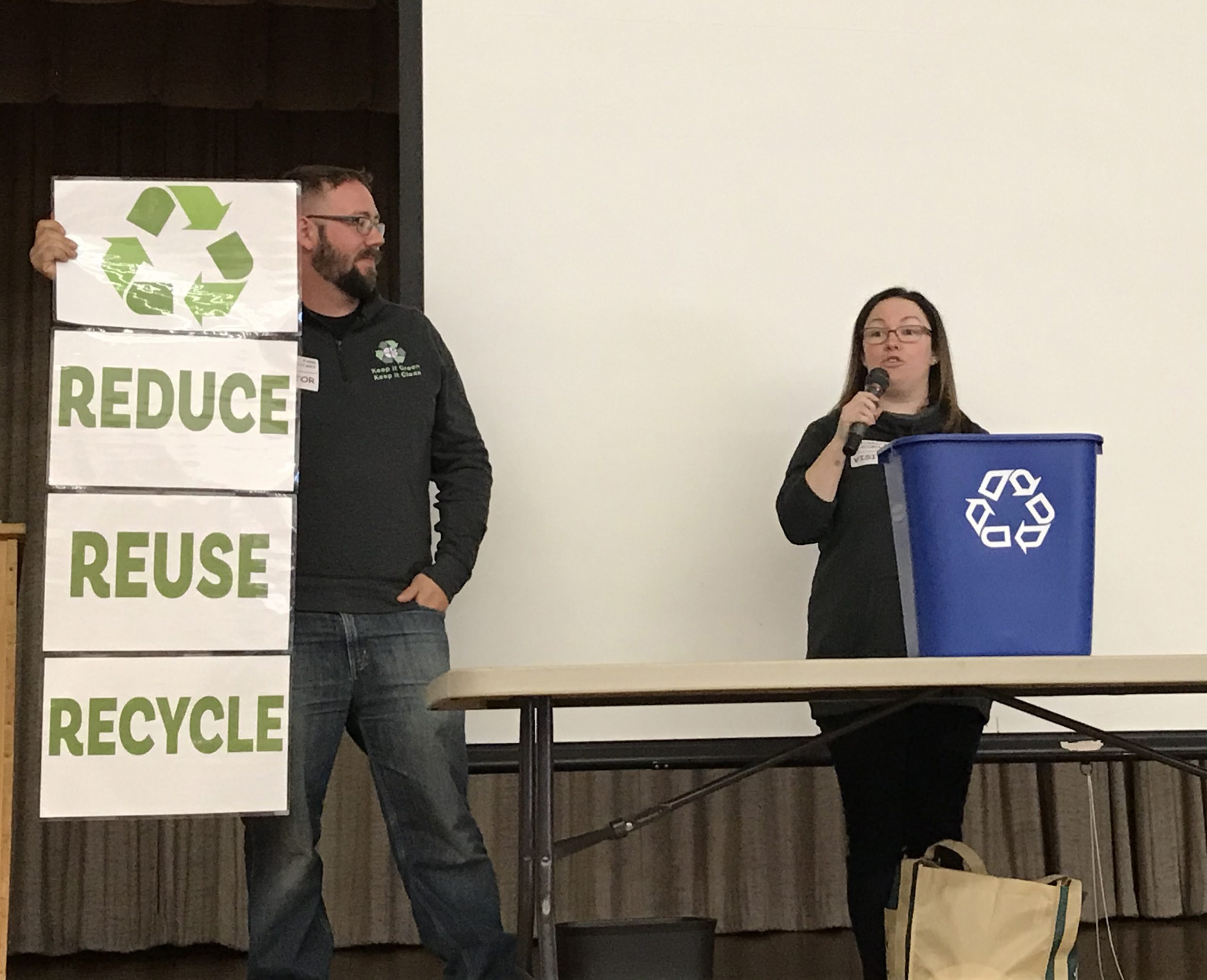 two adults teach kids about recycling