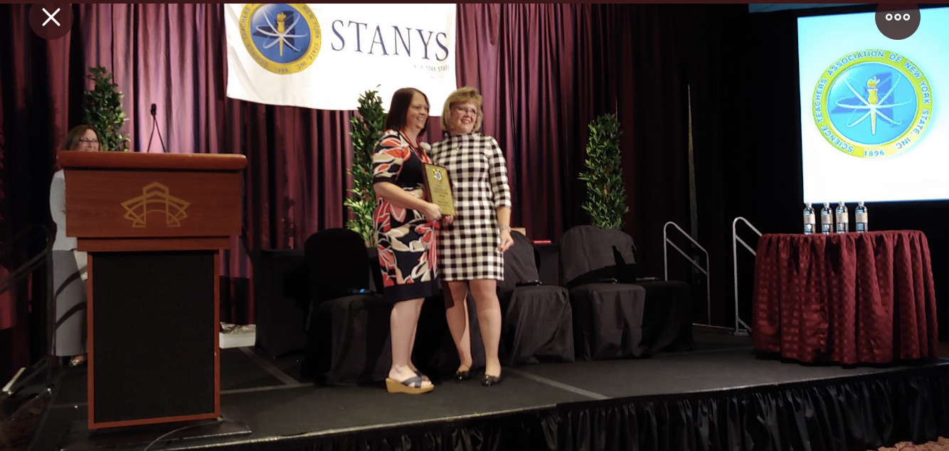 teacher stands with her award