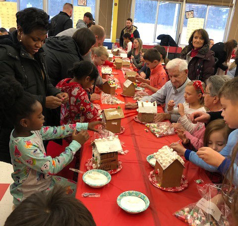 large group of people at a table making candy houses