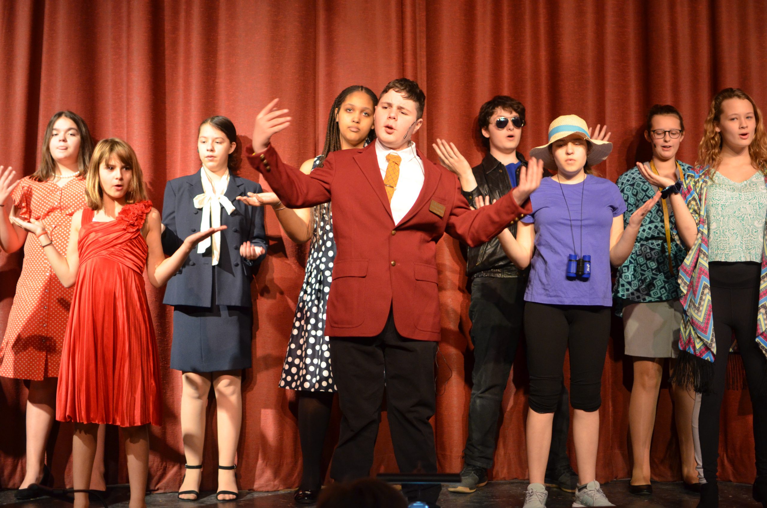 group of middle school actors sing on stage