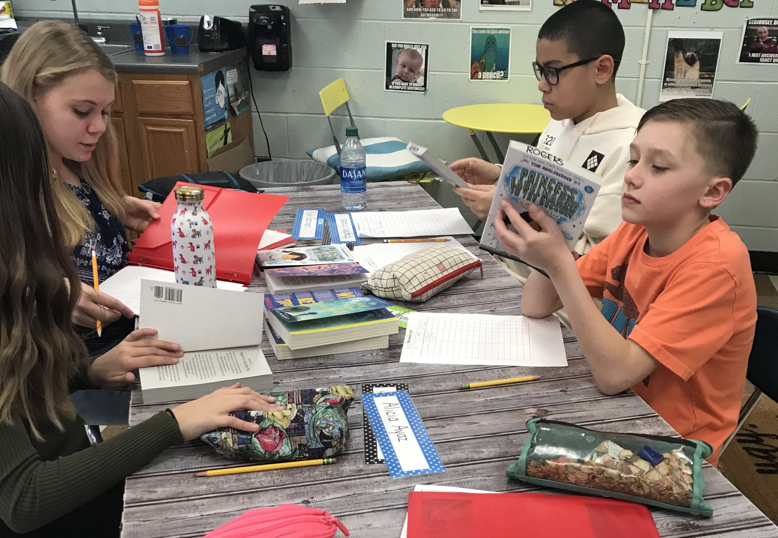 group of students read books at a table