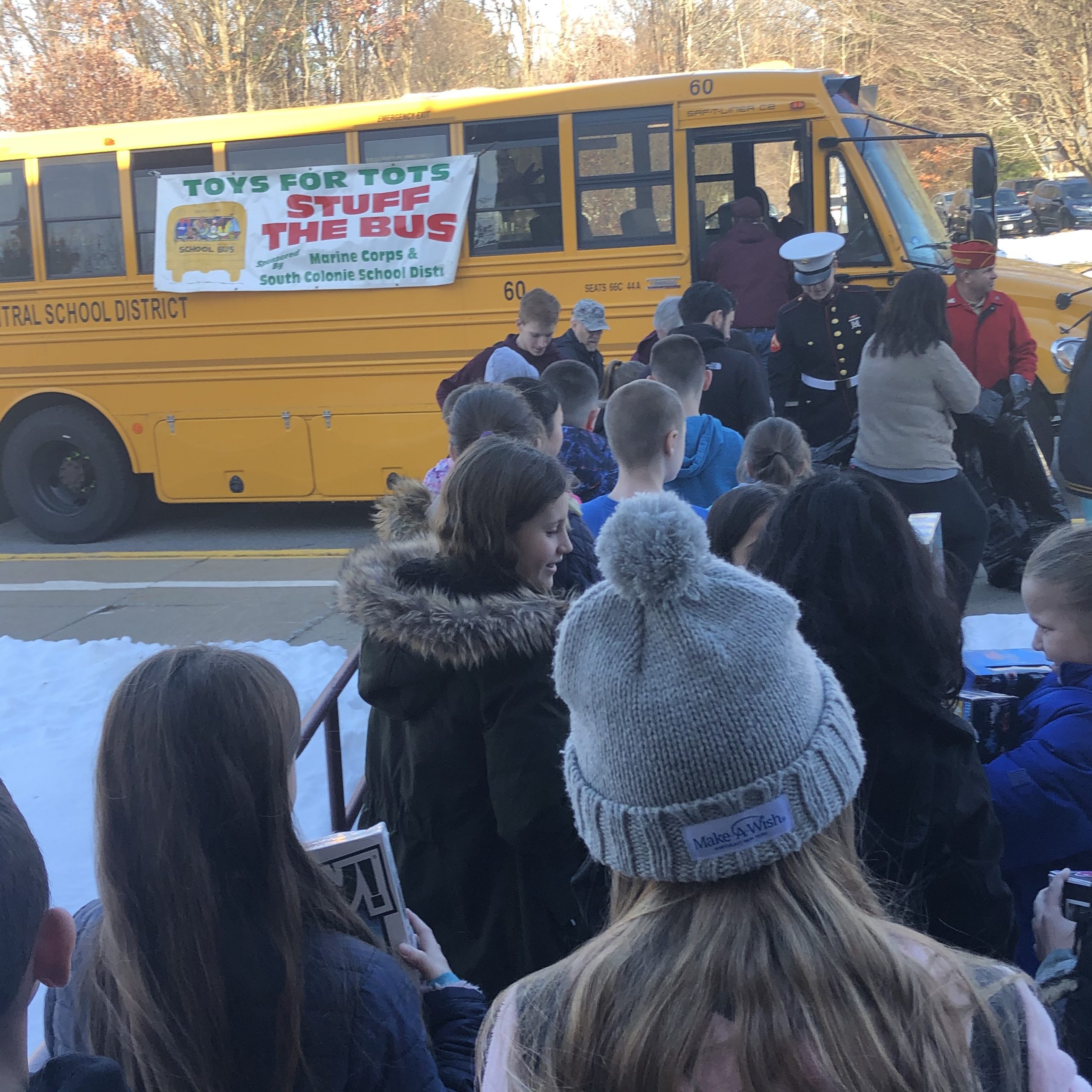 students line up to stuff the school bus with toys