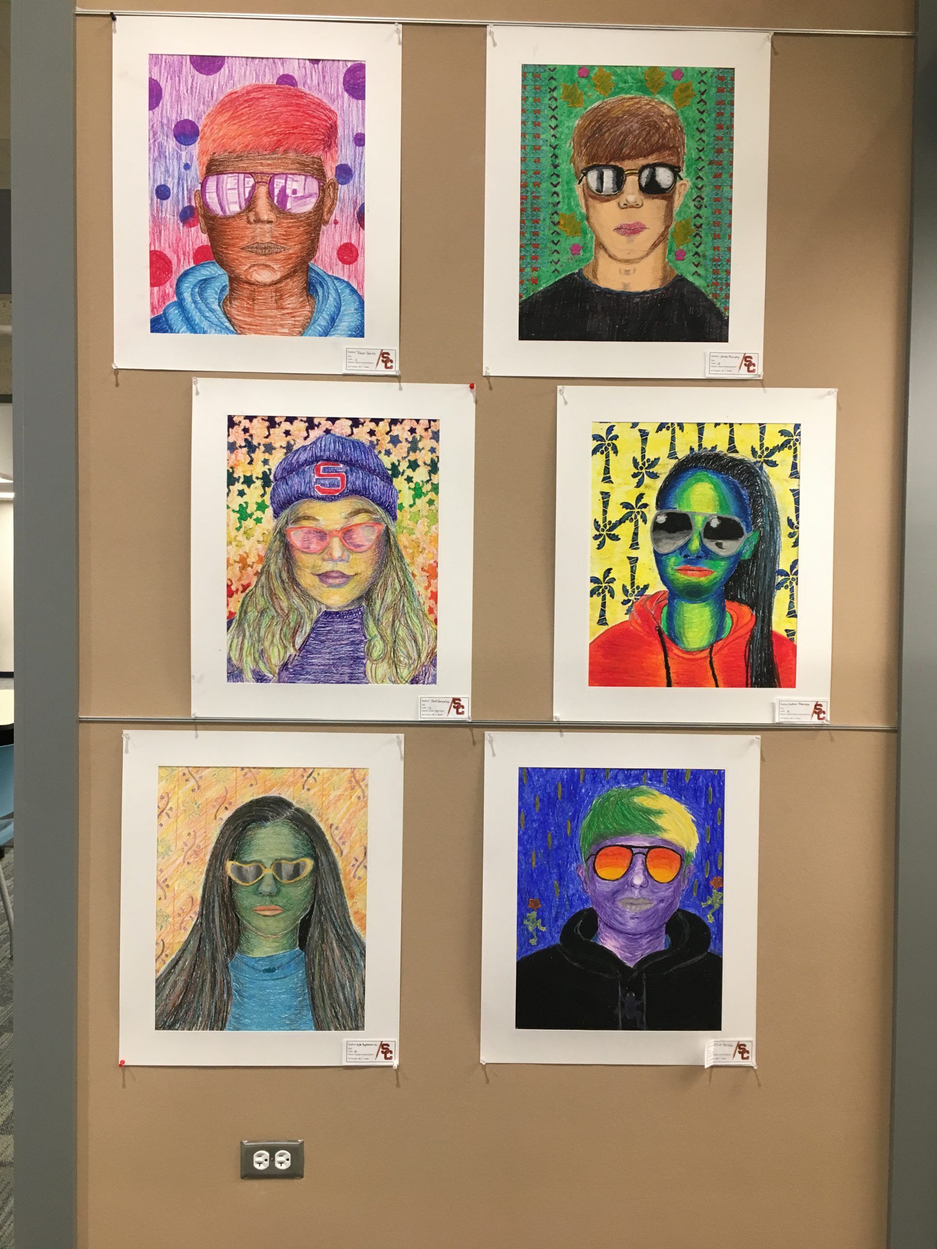 6 student portrait drawings on display