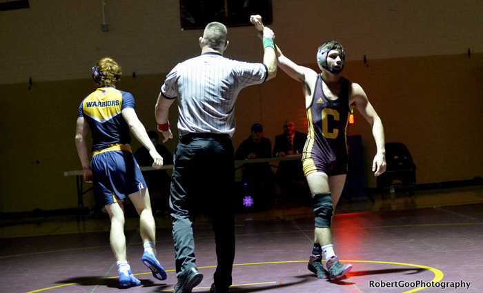 referee raises wrestler's arm in victory