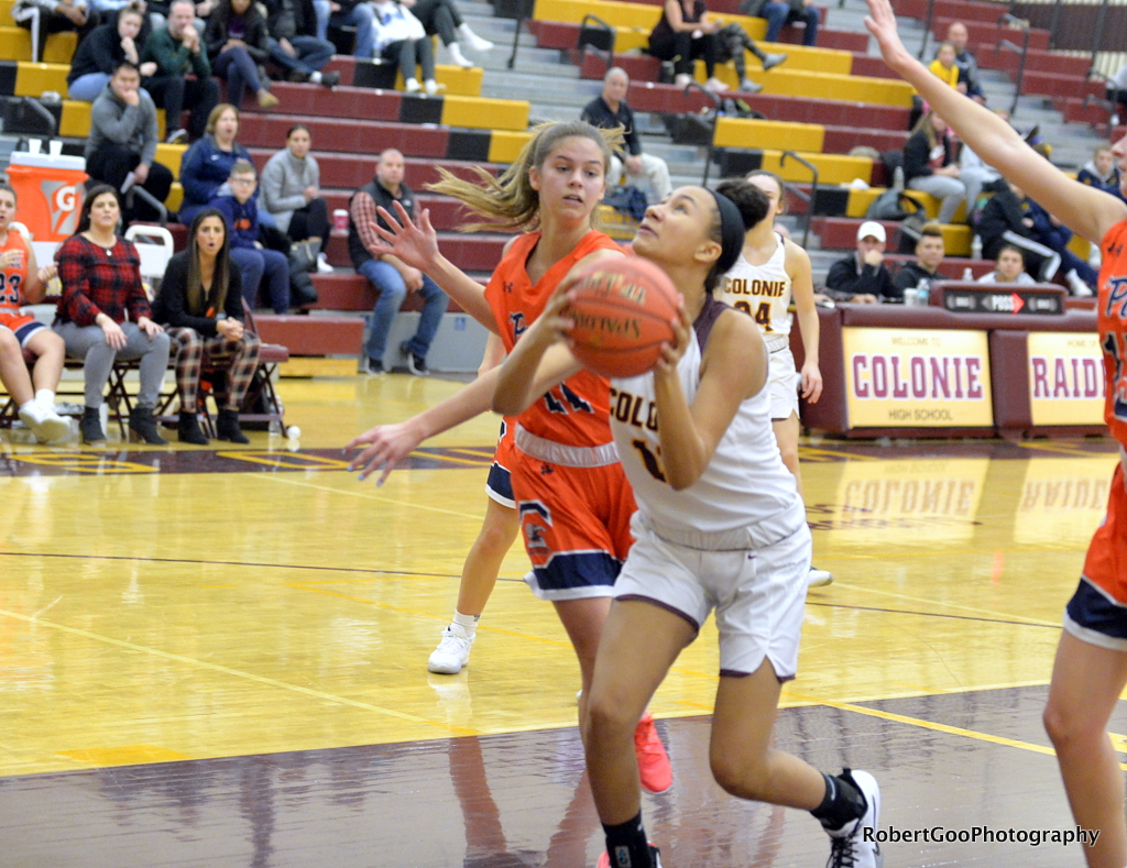 girl basketball player goes to the hoop to score