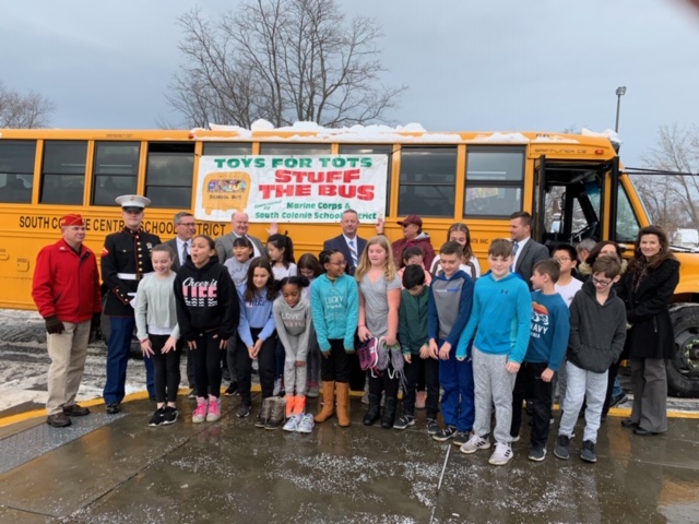 students stand out in front of yellow school bus