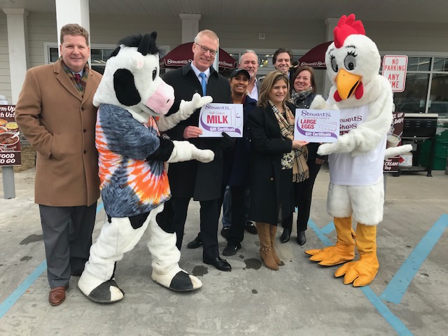 group of people standing together with two mascots at a grand opening of a Stewart's shop.